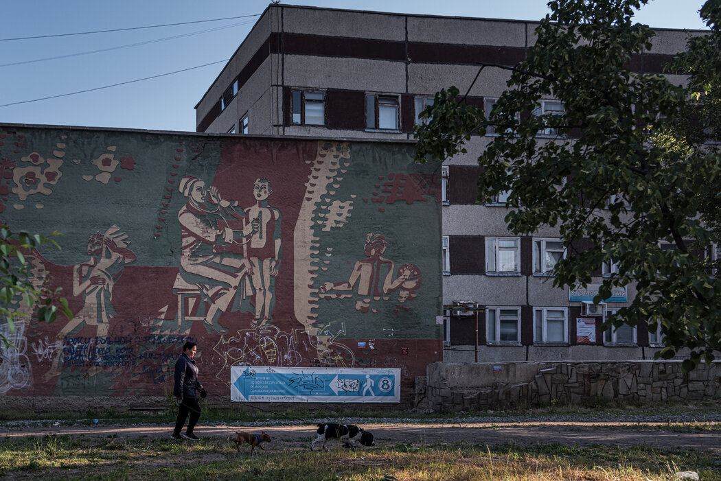 一幅壁画上，医生在诊所外照顾儿童，该地区有人因实验室泄漏而丧生。