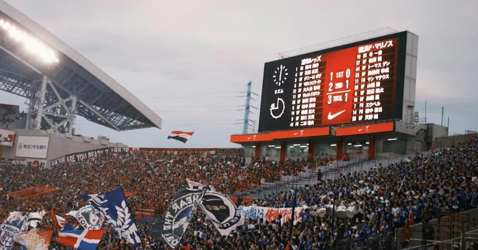 卡在记分板！ 美大学球赛跳伞员遭强风吹歪